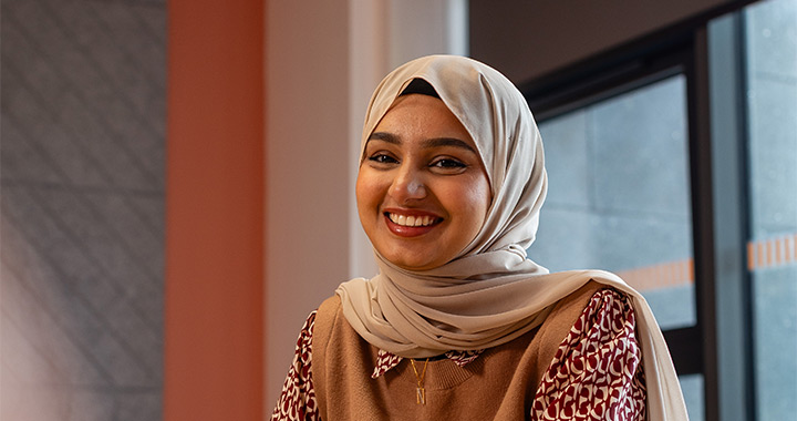 A smiling student sitting in a meeting room. A smiling student sitting in a meeting room.
